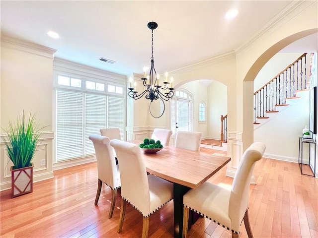 dining area featuring crown molding, a chandelier, and light hardwood / wood-style floors