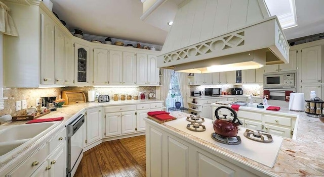 kitchen featuring custom exhaust hood, white appliances, dark wood-type flooring, tasteful backsplash, and white cabinetry