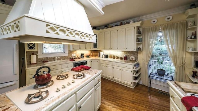 kitchen with sink, dark wood-type flooring, backsplash, white appliances, and custom exhaust hood