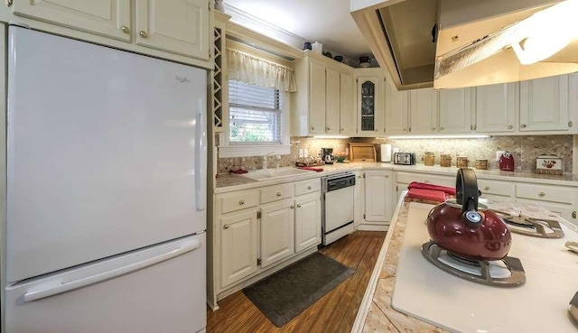 kitchen featuring tasteful backsplash, white appliances, sink, hardwood / wood-style floors, and white cabinetry
