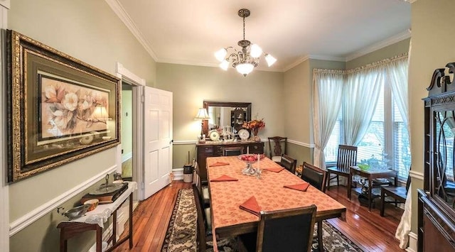 dining room featuring an inviting chandelier, ornamental molding, and hardwood / wood-style flooring