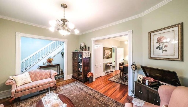living room with hardwood / wood-style flooring, a notable chandelier, and crown molding