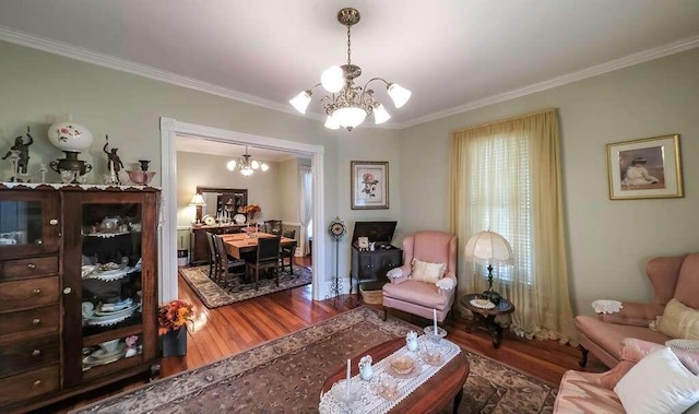 living room with hardwood / wood-style floors, ornamental molding, and a chandelier