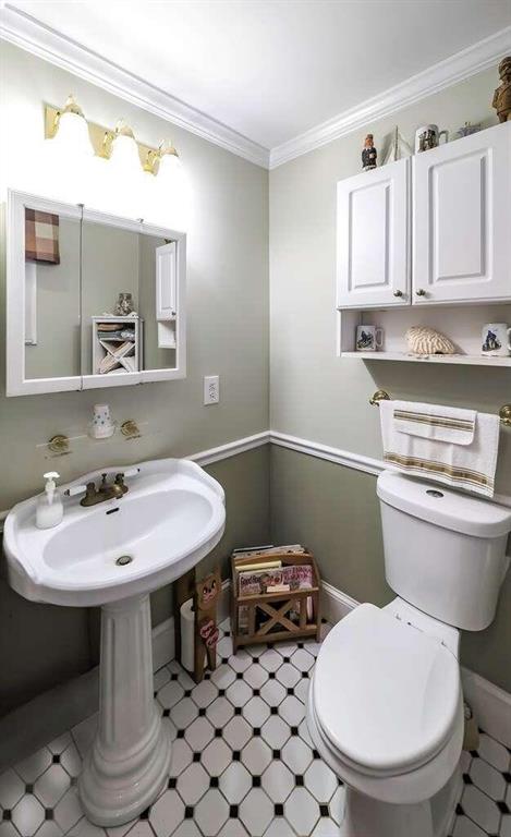 bathroom featuring crown molding and toilet