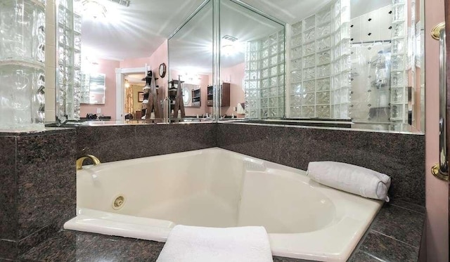 bathroom with a relaxing tiled tub and a wealth of natural light