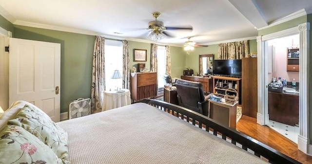 bedroom with hardwood / wood-style flooring, ceiling fan, and crown molding