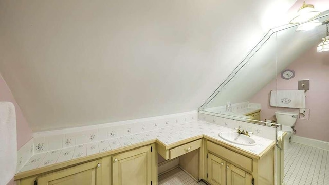 bathroom with tile patterned flooring, vanity, lofted ceiling, and toilet