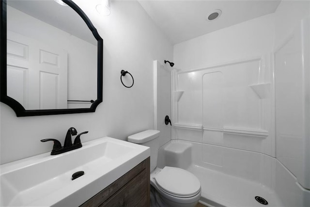 bathroom featuring walk in shower, vanity, and toilet