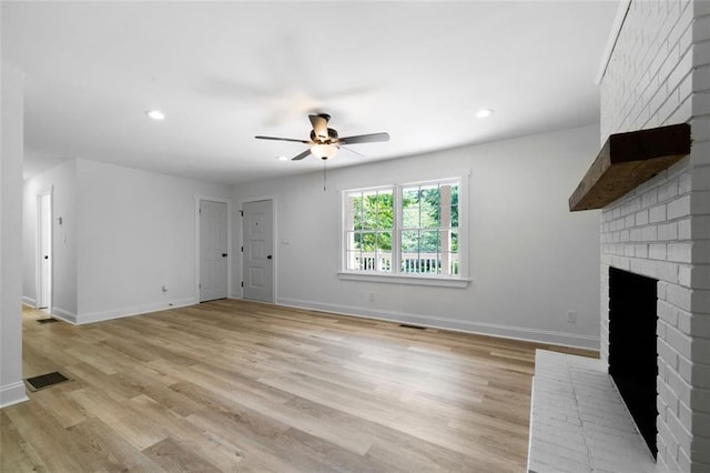 unfurnished living room with a fireplace, ceiling fan, and light hardwood / wood-style flooring