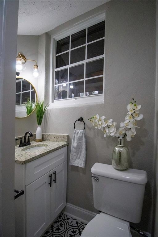 bathroom with vanity, a textured ceiling, and toilet