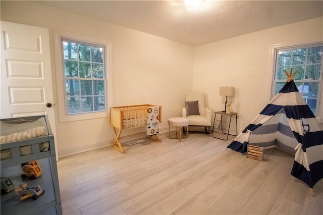 sitting room featuring light hardwood / wood-style floors and a textured ceiling