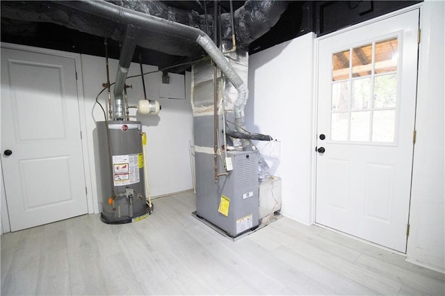 utility room with heating unit and water heater