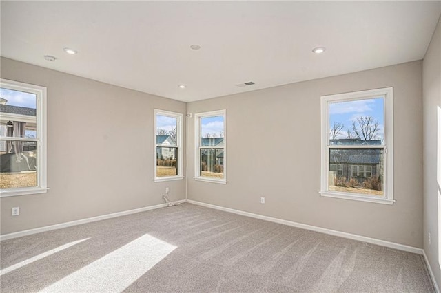 empty room featuring baseboards and light colored carpet