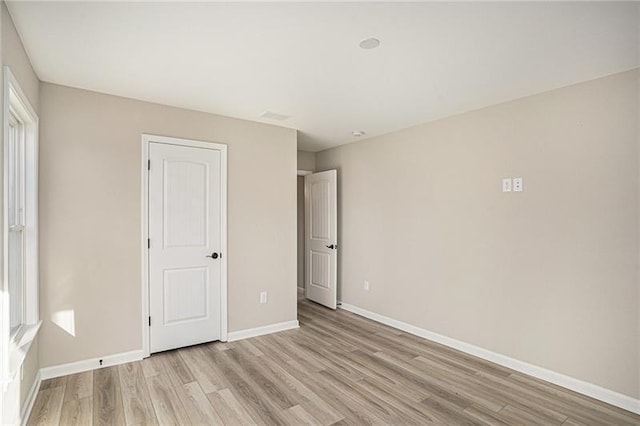 unfurnished bedroom featuring baseboards and light wood-style floors
