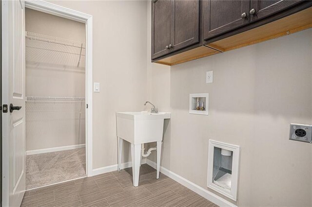 clothes washing area featuring hookup for an electric dryer, cabinet space, washer hookup, and baseboards