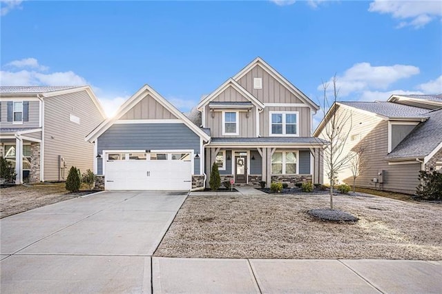 craftsman house with board and batten siding, an attached garage, driveway, and stone siding
