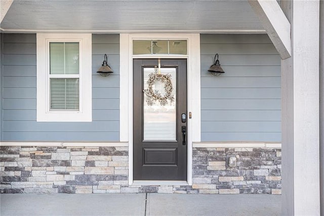 property entrance featuring stone siding and covered porch