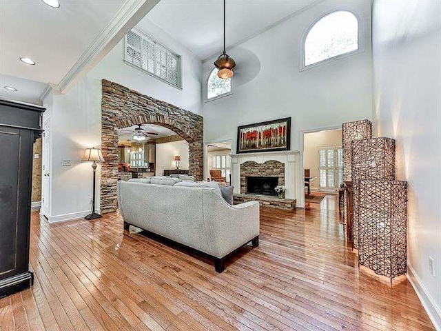 living area with a ceiling fan, hardwood / wood-style flooring, plenty of natural light, and a fireplace