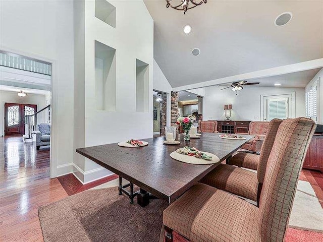 dining area featuring baseboards, high vaulted ceiling, ceiling fan, and wood finished floors