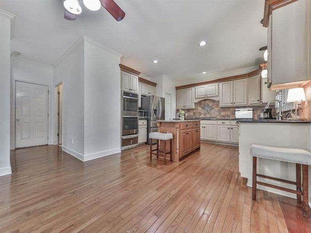 kitchen with light wood-style flooring, ornamental molding, decorative backsplash, ceiling fan, and stainless steel refrigerator with ice dispenser