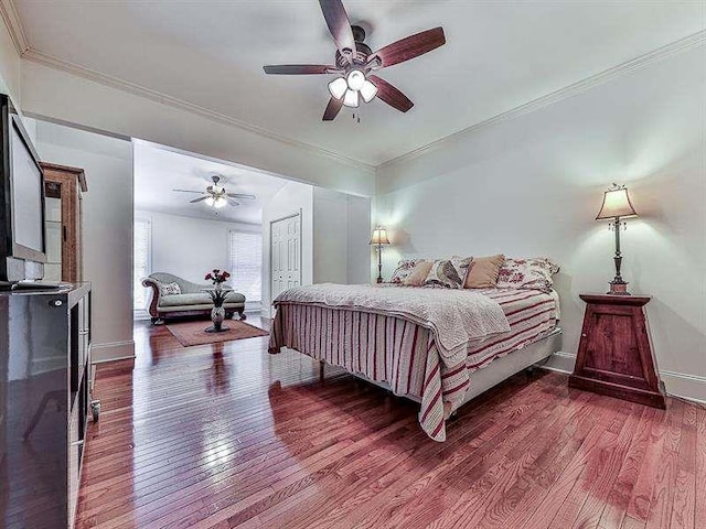 bedroom with wood finished floors and ornamental molding