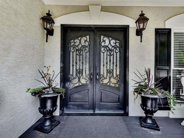 property entrance with french doors and stucco siding