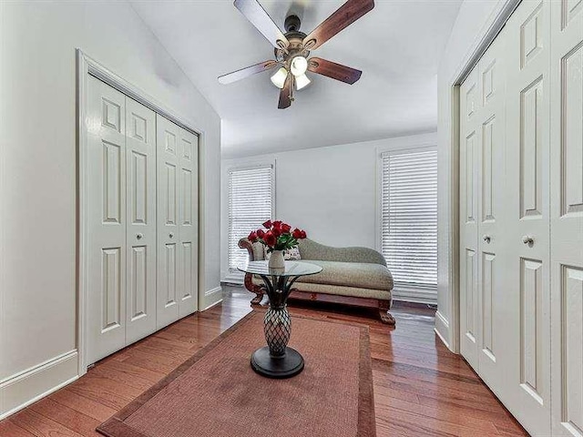 living area featuring ceiling fan, baseboards, and wood finished floors