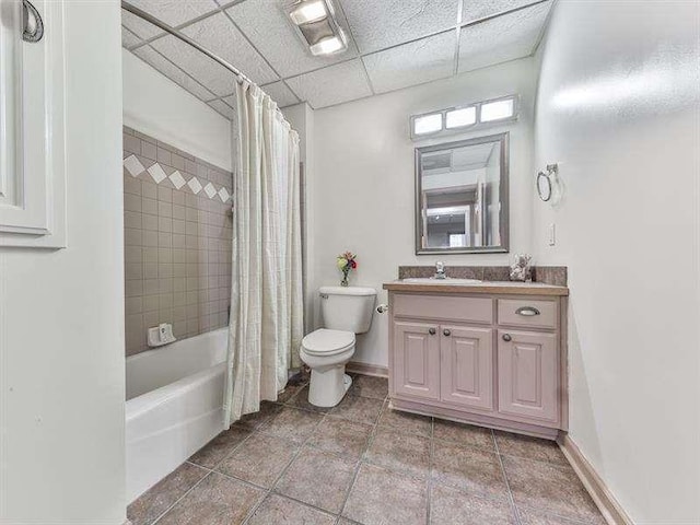 full bath with vanity, shower / bath combo with shower curtain, toilet, and baseboards