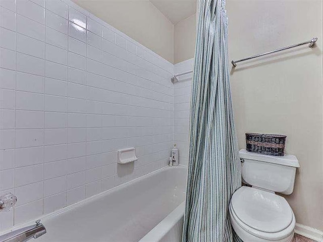 bathroom featuring toilet and shower / bath combo with shower curtain