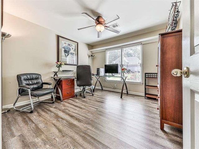 home office with a ceiling fan, wood finished floors, visible vents, and baseboards