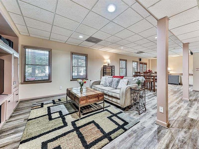 living room with recessed lighting, wood finished floors, baseboards, and a paneled ceiling