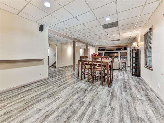 dining room featuring stairway, wood finished floors, and a drop ceiling