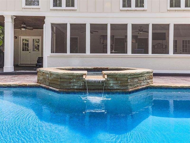 outdoor pool with a ceiling fan and french doors