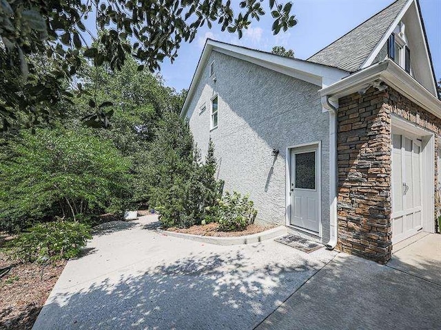 view of property exterior featuring stone siding and stucco siding