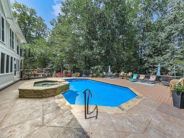 view of pool with a wooden deck, a pool with connected hot tub, and a patio