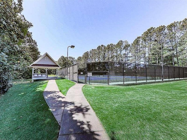 view of sport court with a gazebo, a lawn, and fence