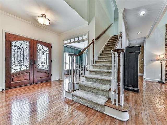 entrance foyer with stairs, hardwood / wood-style flooring, and ornamental molding