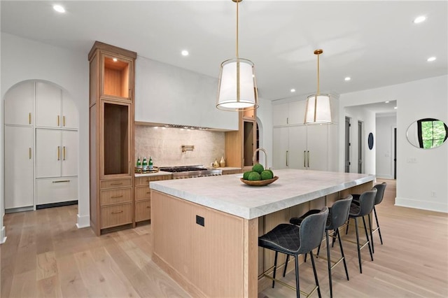 4785 Merlendale Ct, Atlanta, GA 30327 - kitchen featuring light wood-type flooring, backsplash, recessed lighting, light countertops, and a large island