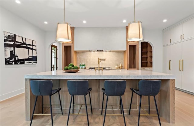 4785 Merlendale Ct, Atlanta, GA 30327 - kitchen with recessed lighting, backsplash, white cabinetry, light wood-style flooring, and hanging light fixtures