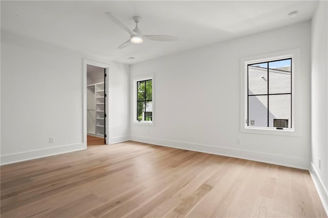 4785 Merlendale Ct, Atlanta, GA 30327 - unfurnished bedroom with light wood finished floors, a spacious closet, baseboards, and a ceiling fan