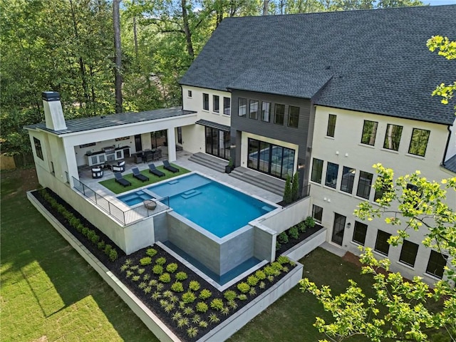 4785 Merlendale Ct, Atlanta, GA 30327 - back of house with a chimney, a pool with connected hot tub, outdoor lounge area, a patio, and a lawn