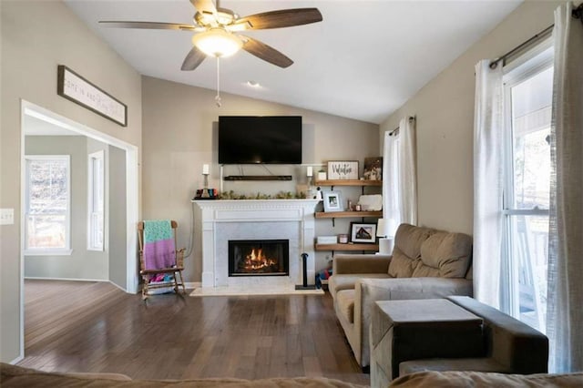 living room featuring a fireplace, lofted ceiling, a ceiling fan, and wood finished floors