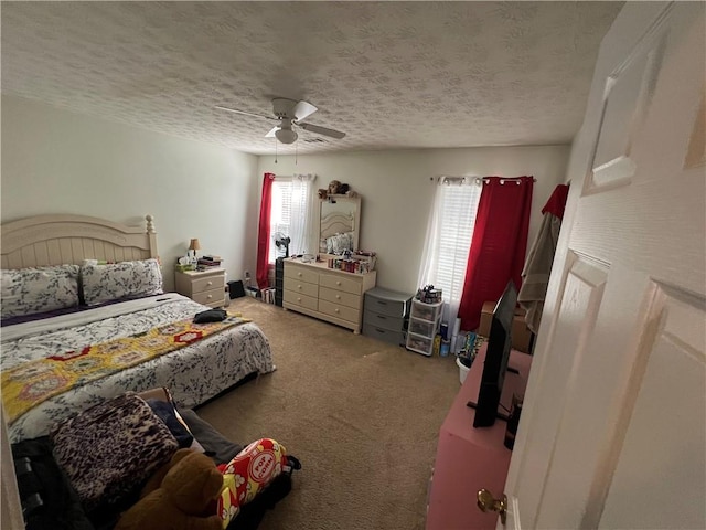 bedroom featuring carpet flooring, a textured ceiling, and ceiling fan