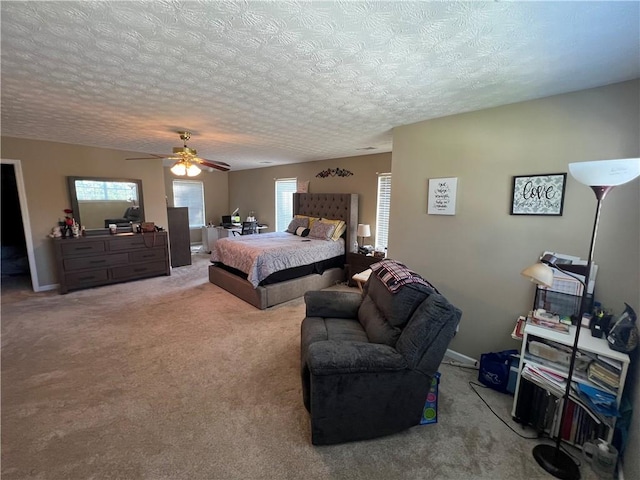 carpeted bedroom with a textured ceiling and ceiling fan