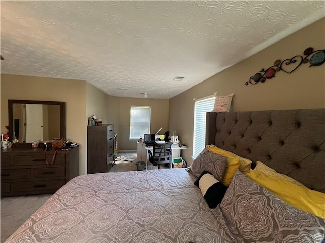 bedroom featuring a textured ceiling and light carpet