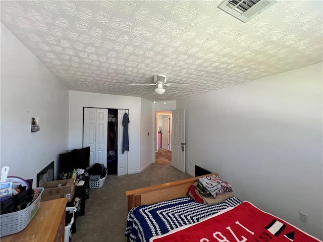 bedroom featuring a textured ceiling, carpet floors, ceiling fan, and a closet