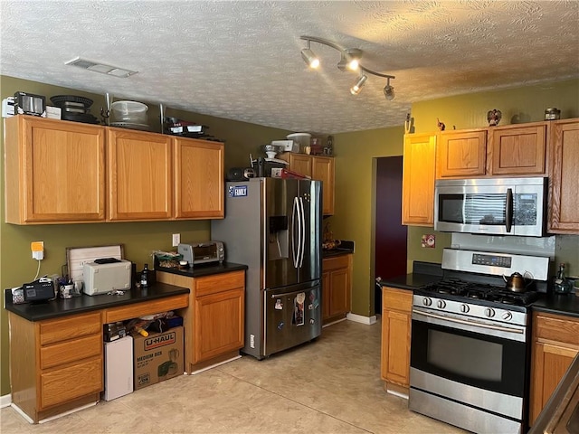 kitchen with appliances with stainless steel finishes and a textured ceiling