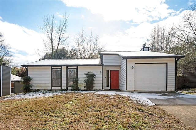 single story home featuring a front yard and a garage