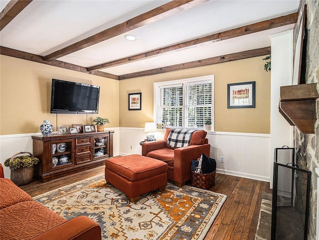 living room featuring beamed ceiling and dark wood-type flooring