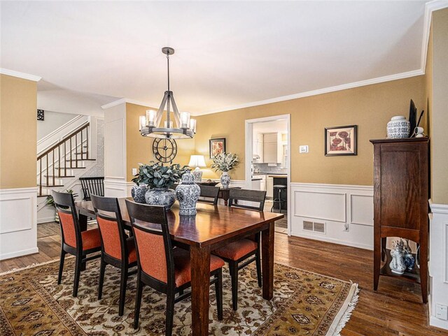 dining room featuring ornamental molding, beverage cooler, dark wood-type flooring, and an inviting chandelier